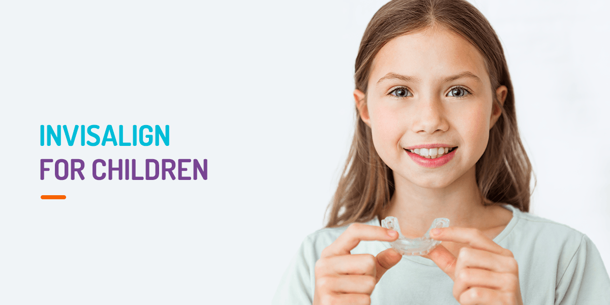Child holding up Invisalign clear aligners